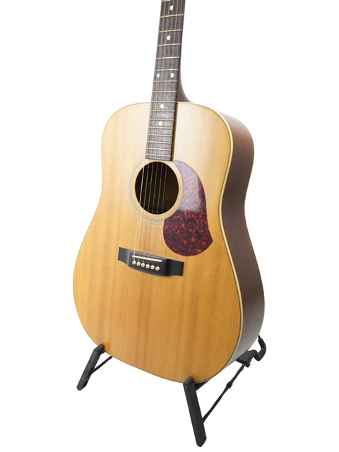  A 1991 Maton CW80/6 guitar resting on a stand, set against a bright white backdrop.