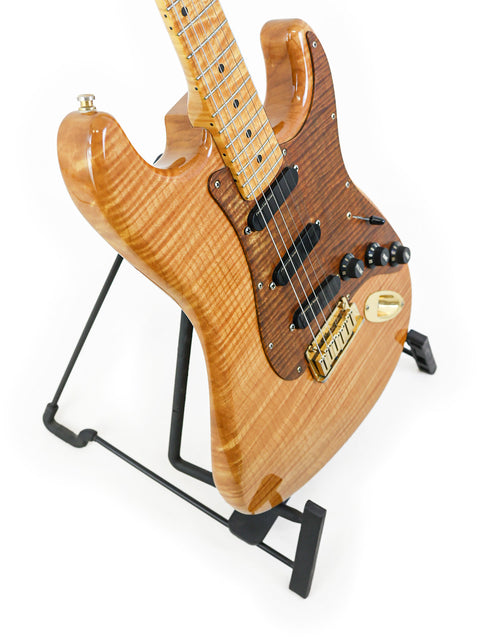 A 1992 Fender Custom Shop 'Clapton' Stratocaster guitar displayed on a stand with a white backdrop.
