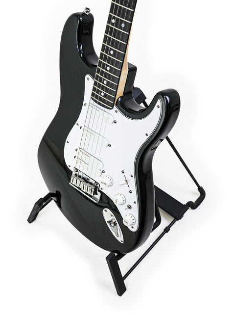 A 1993 black Fender Strat Plus Ultra guitar elegantly positioned on a stand with a stark white backdrop.
