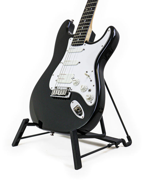 A 1993 black Fender Strat Plus Ultra guitar elegantly positioned on a stand with a white backdrop.