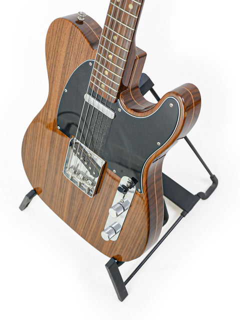 A 2003 Fender Masterbuilt Telecaster featuring a wooden body and black pick guard, highlighting its unique limited edition design.