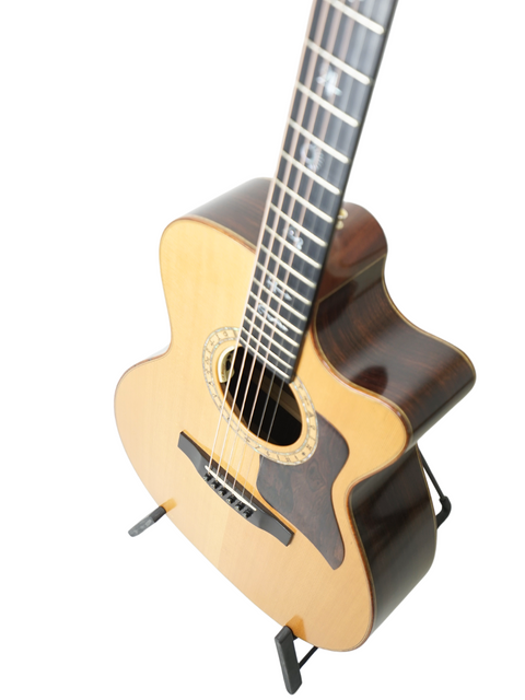 A 2004 Lakewood M-NC CP New Century II Grand Concert guitar resting on a stand, set against a bright white background.