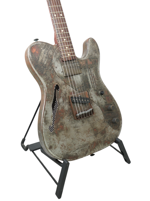 A 2006 James Trussart Steelcaster guitar with a rustic finish, elegantly positioned on a stand, emphasizing its unique character.