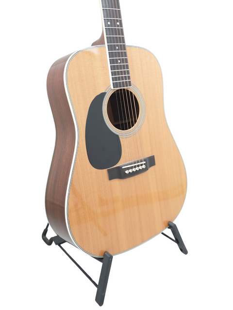 A 2009 Martin D-35 Left-Handed guitar resting on a stand, set against a simple white backdrop.