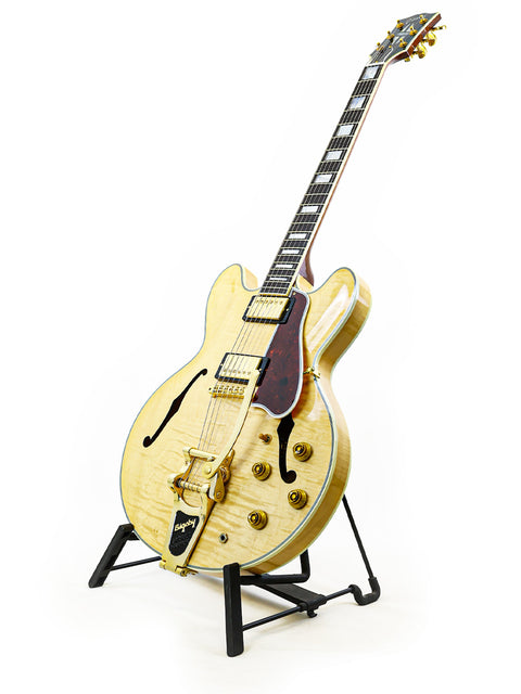A 2011 Gibson Custom Shop ES-355 guitar displayed on a stand, highlighting its classic style and quality.