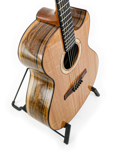 A 2013 Gary Rizzolo SJ Custom guitar on a stand, set against a white backdrop, highlighting its craftsmanship and style.
