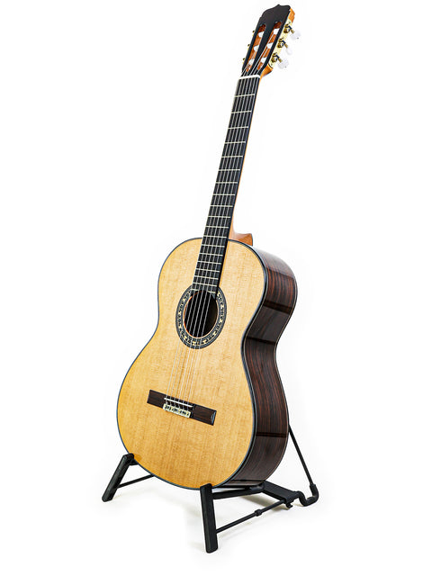  A 2019 José Ramírez Estudio 3 Classical guitar elegantly positioned on a stand, contrasting against a bright white background.