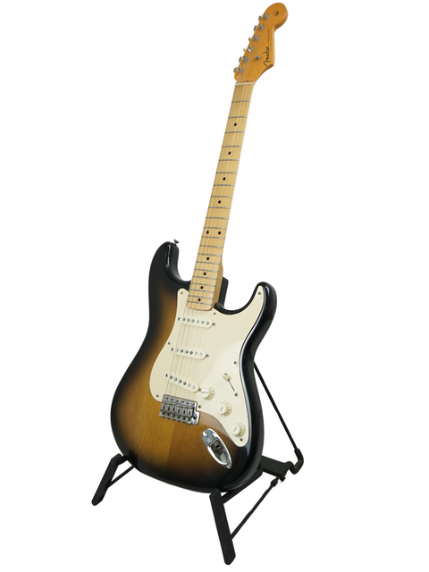 A Fender Eric Johnson Signature Stratocaster guitar displayed on a stand with a bright white backdrop.