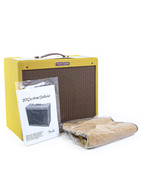 A Fender guitar amplifier with manual and cover on white background.