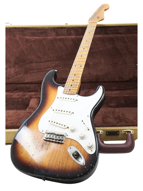 A Fender guitar in a brown case, representing the Nacho Guitars 50s Stratocaster, crafted in Spain, 2024.

