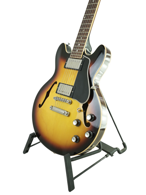 A Gibson Custom Shop ES-339 guitar with a sunburst finish, elegantly resting on a stand, made in the USA in 2009.