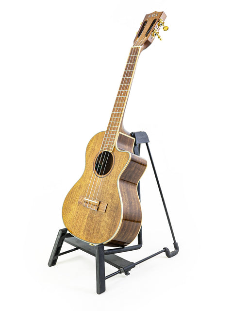 A Kala KA-KTGE-C Hawaiian Koa Tenor Cutaway Ukulele displayed on a stand against a clean white background.