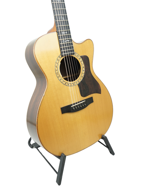 A Lakewood M-NC CP New Century II Grand Concert guitar from Germany, elegantly positioned on a stand for display.