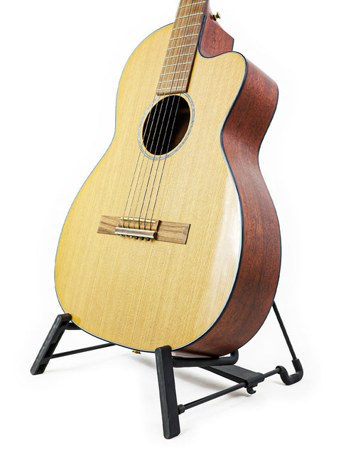 A Martin 000C-16SGCTNE guitar from 2003 resting on a stand, set against a bright white background.