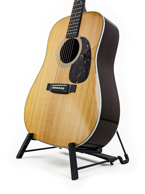 A Martin HD-28 acoustic guitar displayed on a stand, highlighting its 2006 USA craftsmanship.