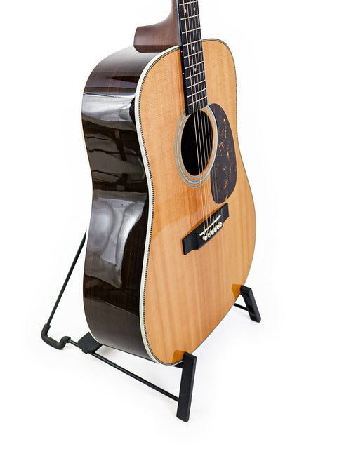 A Martin HD-28 guitar from 2006 displayed on a stand against a clean white background.