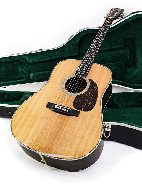 A Martin HD-28 guitar inside a green case, highlighting its classic style and quality from the USA, made in 2006.