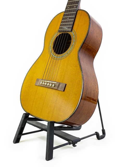 A Martin Sting Mini Signature Edition guitar on a stand, featuring a white background. Signed by Sting, limited to 100, USA 2005.