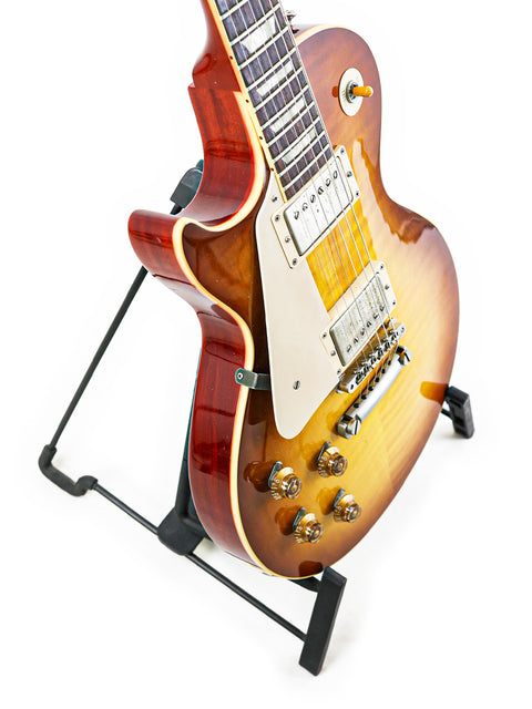A beautiful Gibson Custom Shop LPR-8 Left-Handed guitar on a stand, contrasted against a smooth white background for emphasis.