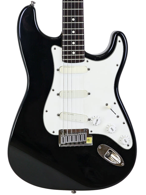 A black Fender Strat Plus electric guitar with a white pickguard, USA model from 1991, showcasing its sleek design.