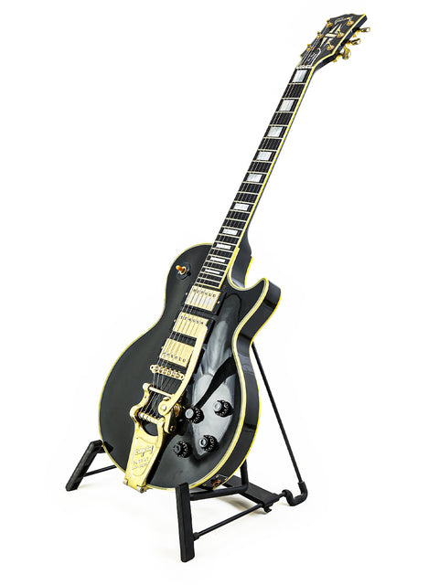 A black and gold Gibson Les Paul Custom B3 guitar from 2004, proudly displayed on a stand, emphasizing its craftsmanship.