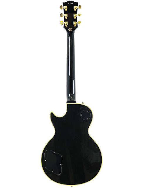 A black electric guitar featuring gold hardware, the 2004 Gibson Custom Shop 1957 Les Paul Custom B3 'Black Beauty' Reissue.
