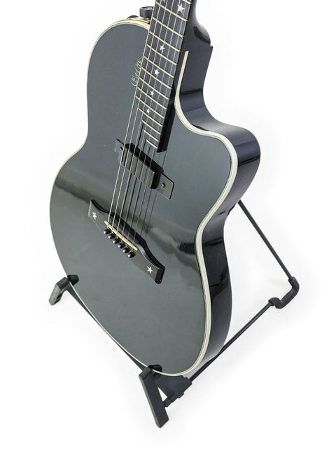 A black guitar, the Gibson Chet Atkins SST from 2001, displayed on a stand with a stark white background.
