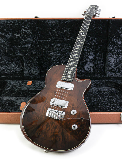 A brown Taylor Solid Body guitar from 2007 nestled in its case, set against a simple white background.