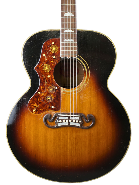 A classic 1955 left-handed Gibson J-200 guitar featuring a beautiful sunburst finish and warm brown body.