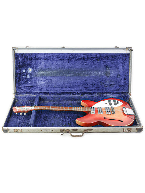 A classic 1959 Gibson Les Paul electric guitar, highlighting its iconic shape and finish, next to a 1965 Rickenbacker 1998.