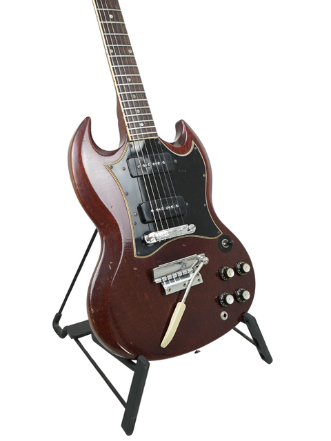 A classic 1967 Gibson SG Special electric guitar in brown, prominently positioned on a stand.