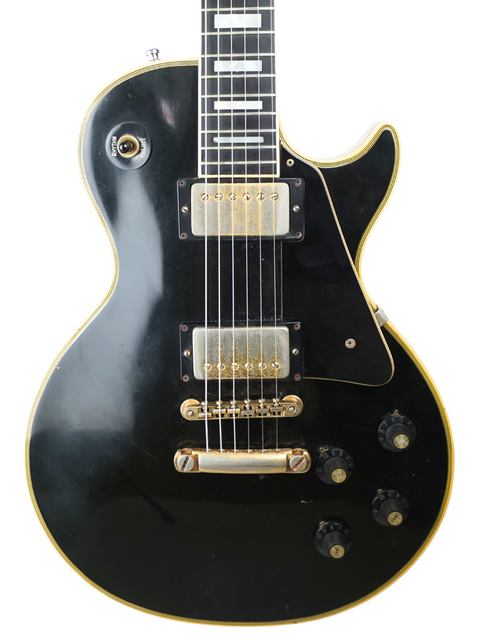 A classic 1973 Gibson Les Paul Custom Black Beauty electric guitar, showcasing a striking black body with luxurious gold accents.