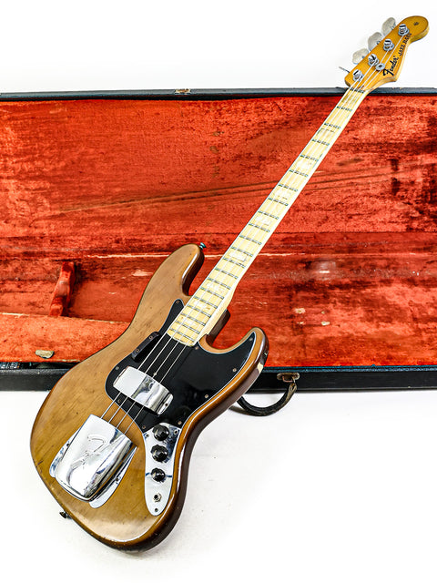 A classic 1974 Fender Jazz Bass guitar safely stored in its case, highlighting its vintage appeal and iconic style.
