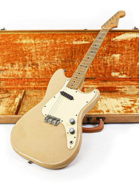 A classic beige electric guitar, the 1957 Fender Musicmaster, resting in a vintage case, ready for a jam session.