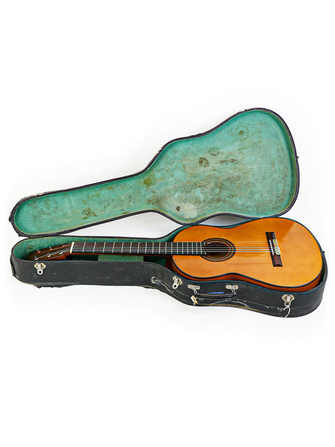 A classic guitar alongside its case on a clean white backdrop, highlighting M.G. Contreras' work from Spain, 1973.