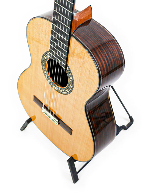 A classical guitar, José Ramírez Estudio 3 from Spain (2019), displayed on a stand with a minimalist white backdrop.