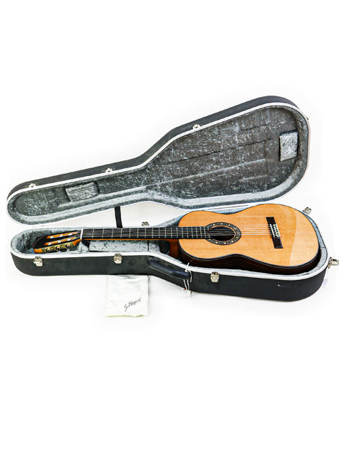 A classical guitar, José Ramírez Estudio 3 from Spain (2019), securely placed in a case against a bright white backdrop.
