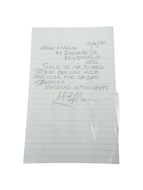 A close-up of a handwritten note on paper with a pen, showcasing a vintage Vox AC-30 Top Boost from 1975, ex. Hank Marvin.