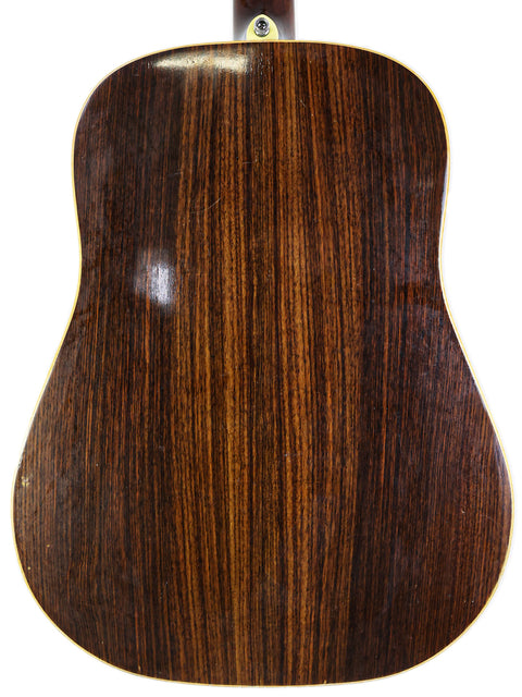 A close-up of the back of an acoustic guitar with a rich brown wood finish, marked Jim Williams WD-40, Australia 2005.