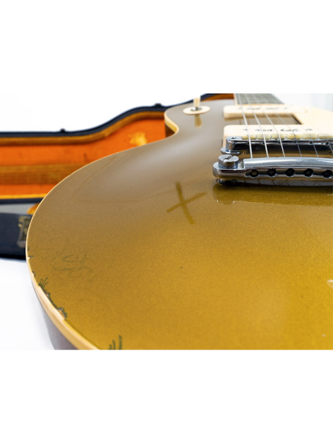 A gold Gibson Les Paul Standard guitar from 1968, elegantly placed in its case on the floor, emphasizing its vintage appeal.
