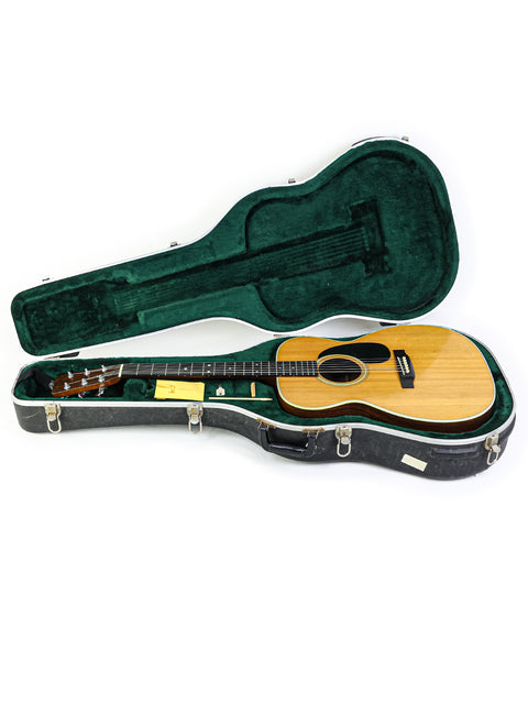 A green case containing a vintage Martin 000-28 guitar from 1976, emphasizing its timeless elegance and heritage.