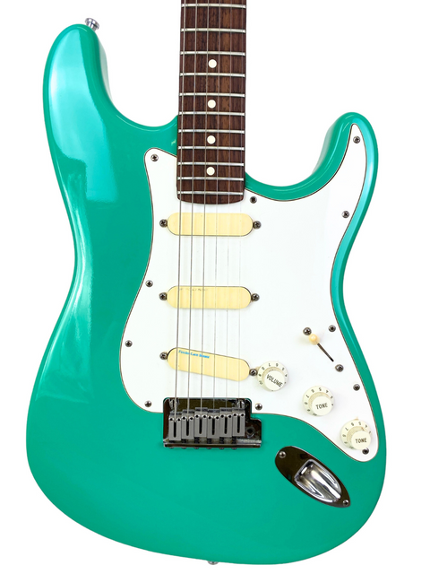 A green electric guitar with a white body, featuring the Fender Strat Plus Deluxe model from the USA, 1989.
