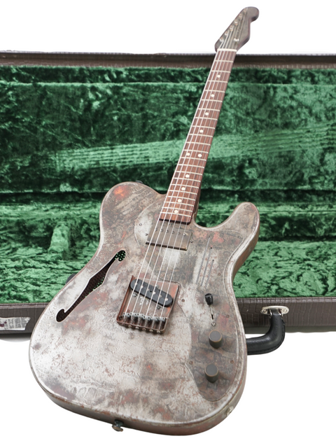 A green guitar case containing a James Trussart Steelcaster, highlighting its distinctive style and 2006 USA craftsmanship.