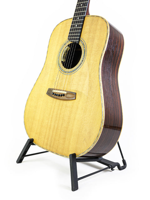 A guitar displayed on a stand with a clean white backdrop, highlighting its features. Jim Williams WD-40, Australia 2005.