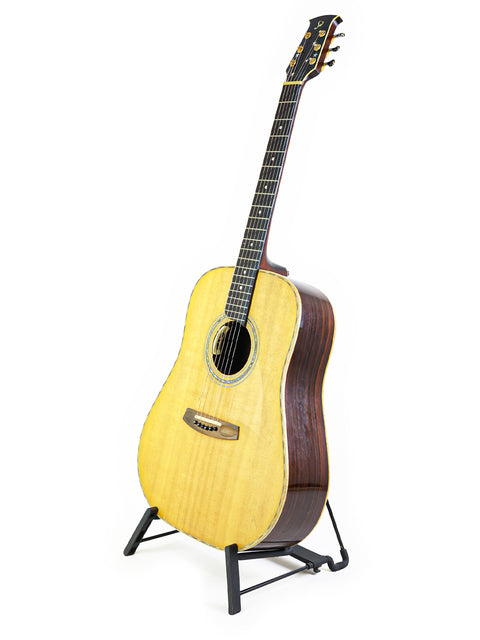A guitar displayed on a stand with a white backdrop, highlighting its features. Jim Williams WD-40, Australia 2005.