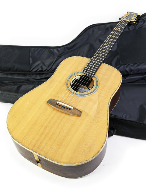 A guitar inside a case against a white backdrop, featuring the label 'Jim Williams WD-40 - Australia 2005'.