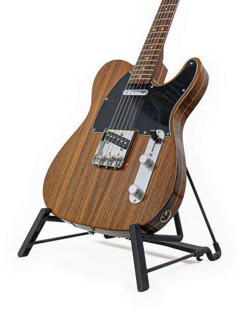 A limited edition Fender Masterbuilt John English Rosewood Telecaster guitar displayed on a stand, featuring a rich wooden body.
