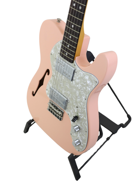 A pink electric guitar with a white pickguard on a black stand against a white background.
