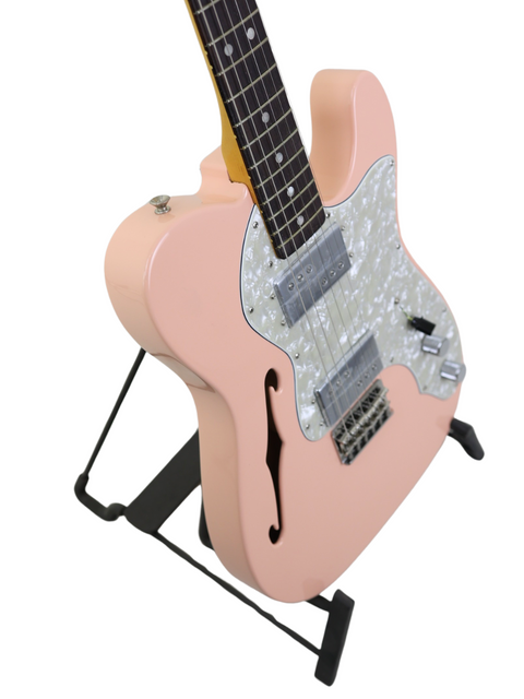 A pink electric guitar with a white pickguard on a black stand, isolated on a white background.