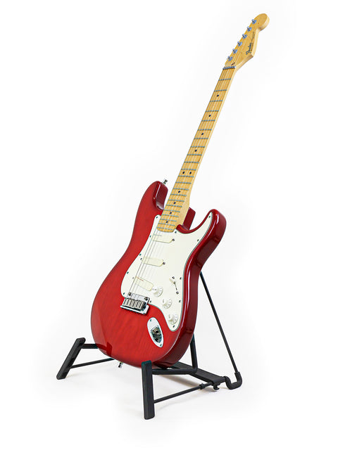 A red 1993 Fender Strat Plus Deluxe guitar elegantly positioned on a stand with a white backdrop.
